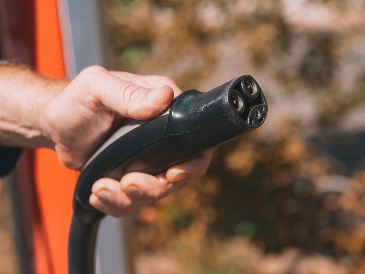 Hand holding an EV charging cable connector